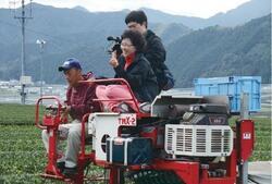 写真:農作業機械に乗るメディア関係者