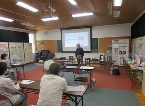 写真:講師がスクリーンを見ながら話をする様子