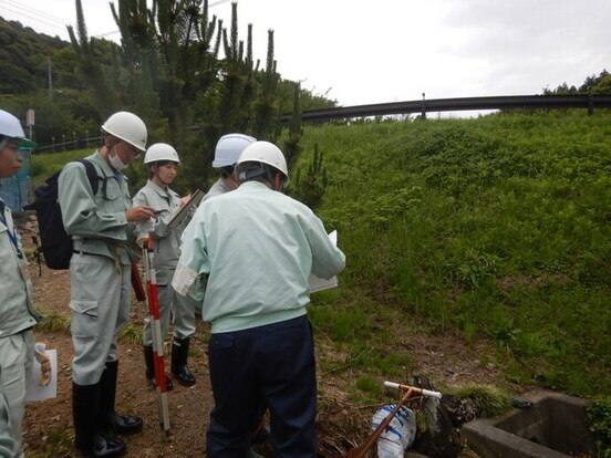 地元住民に地すべり防止施設(排水路)の説明をしている写真