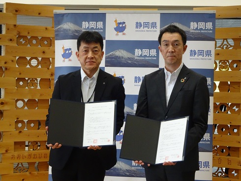 協定書を披露する山田財務部長（左）、八木清水銀行取締役（右）の写真
